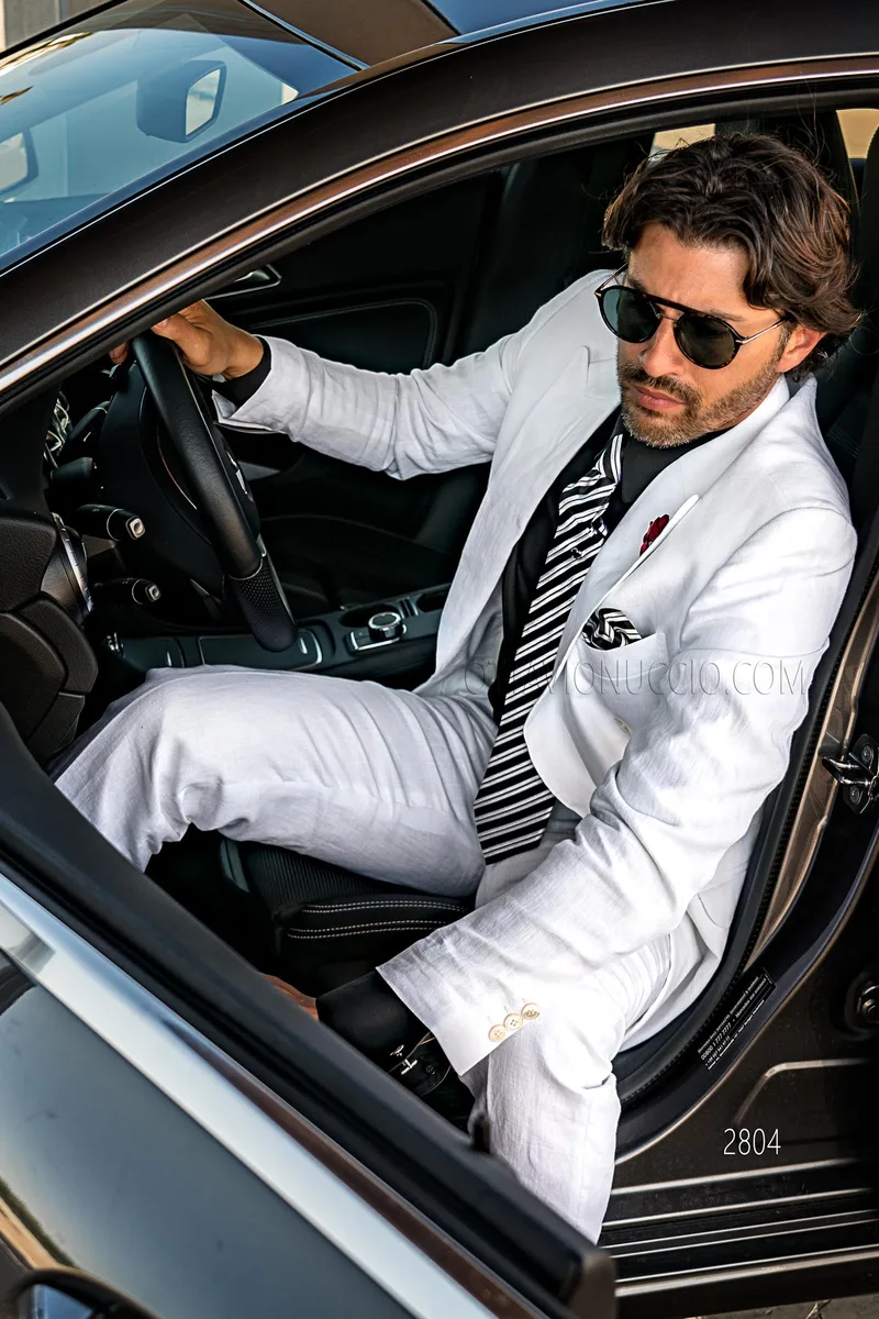 Traje de ceremonia para hombre cruzado en puro lino blanco con combinación negra – Plano americano